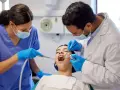 Dentiste et assistante examinant une patiente. Le coût d'une étude orthodontiste peut varier.