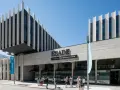 Devant l'ESADE Barcelone, une école reconnue pour son classement, des étudiants discutent sous un ciel bleu.