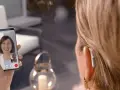 Une femme avec un appareil auditif participe à une formation audioprothésiste à distance via un appel vidéo.