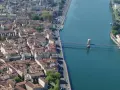 Vue aérienne de la ville de Vienne, traversée par un fleuve et un pont. L'école de Vienne se reflète dans l'eau.