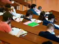 Étudiants masqués en classe, concentrés sur leurs notes. Un aperçu du coût de la vie au Danemark, où l'éducation est une priorité.