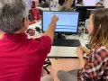 Un homme montre un audiogramme sur un écran, peut-être lors d'une formation pour obtenir son diplôme d'audioprothésiste en Espagne.