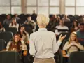 Professeure s'adressant à des étudiants dans un amphithéâtre, un lieu d'apprentissage pour une école de commerce publique gratuite.