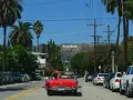 Voiture rouge décapotable, palmiers, panneau Hollywood. Le cout de la vie USA, un rêve pour certains, une réalité coûteuse pour d'autres.
