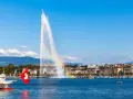 Le Jet d'Eau de Genève, un arc-en-ciel dans la brume, symbolise la beauté de comment vivre en Suisse.