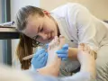 Étudiante en podologie en Belgique, elle soigne un pied avec soin.