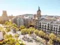 Vue aérienne de Barcelone, ville dynamique qui pourrait figurer dans le classement université espagne. Bâtiments haussmanniens, arbres luxuriants et ciel bleu.