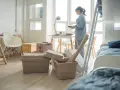 Une jeune femme déballe ses affaires dans une chambre d'étudiant au Canada. Valises et boîtes sont empilées, prête pour une nouvelle vie.