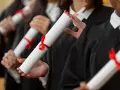 Diplômés en toges noires tenant des parchemins, un rêve pour ceux qui veulent faire ses études de kiné en Europe.