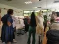 Des élèves d'une école de mode gratuite présentent leurs créations sur des mannequins. Une enseignante explique un tableau d'inspiration.