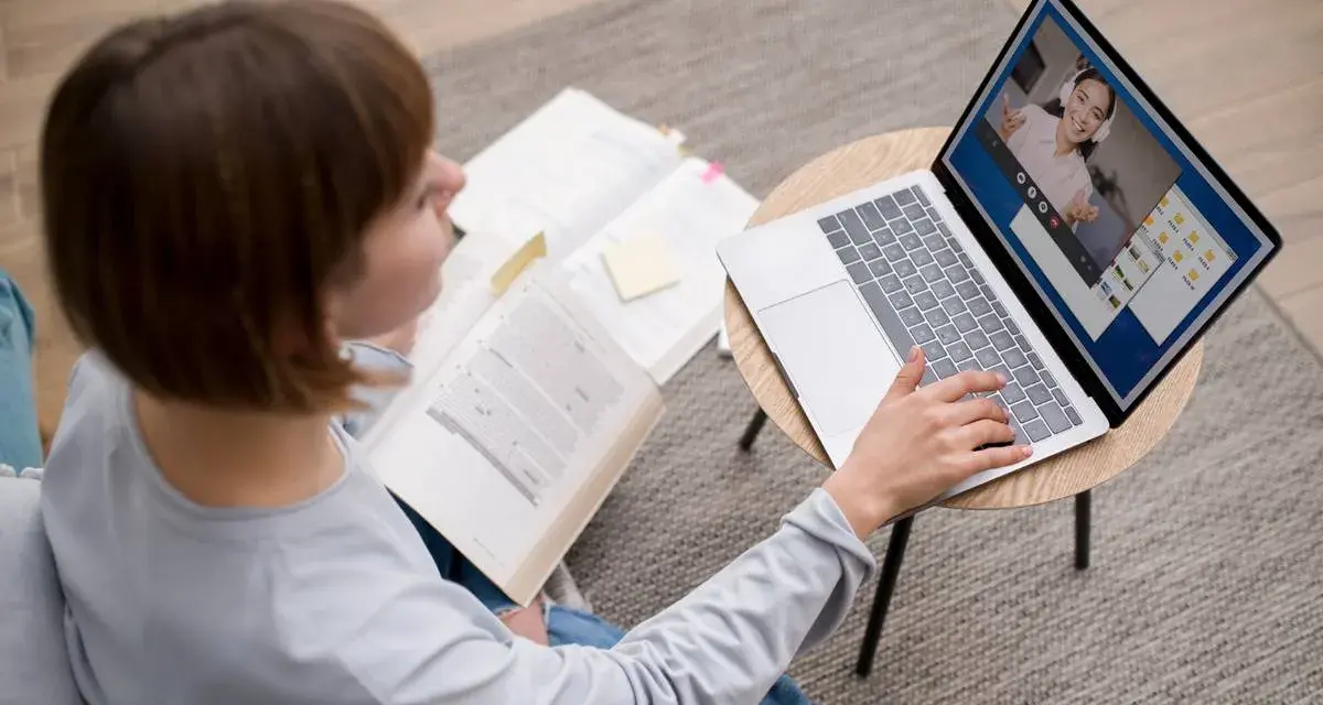 Étudiante en licence neurosciences à distance, elle étudie sur son ordinateur portable et des livres ouverts.