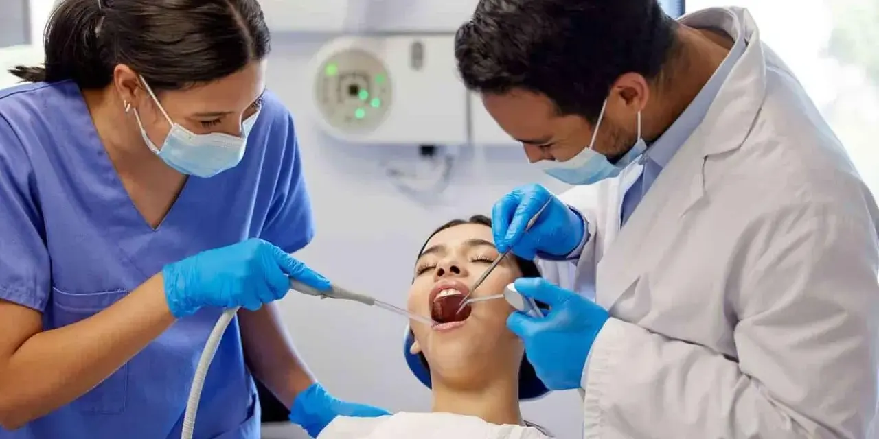 Dentiste et assistante examinant une patiente. Le coût d'une étude orthodontiste peut varier.