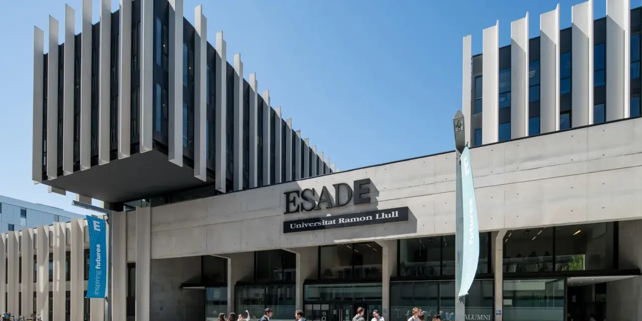 Devant l'ESADE Barcelone, une école reconnue pour son classement, des étudiants discutent sous un ciel bleu.