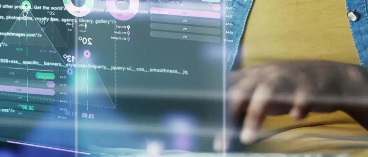 Un expert en master cybersécurité à distance analyse des données complexes sur un écran, jonglant avec des codes et des graphiques.