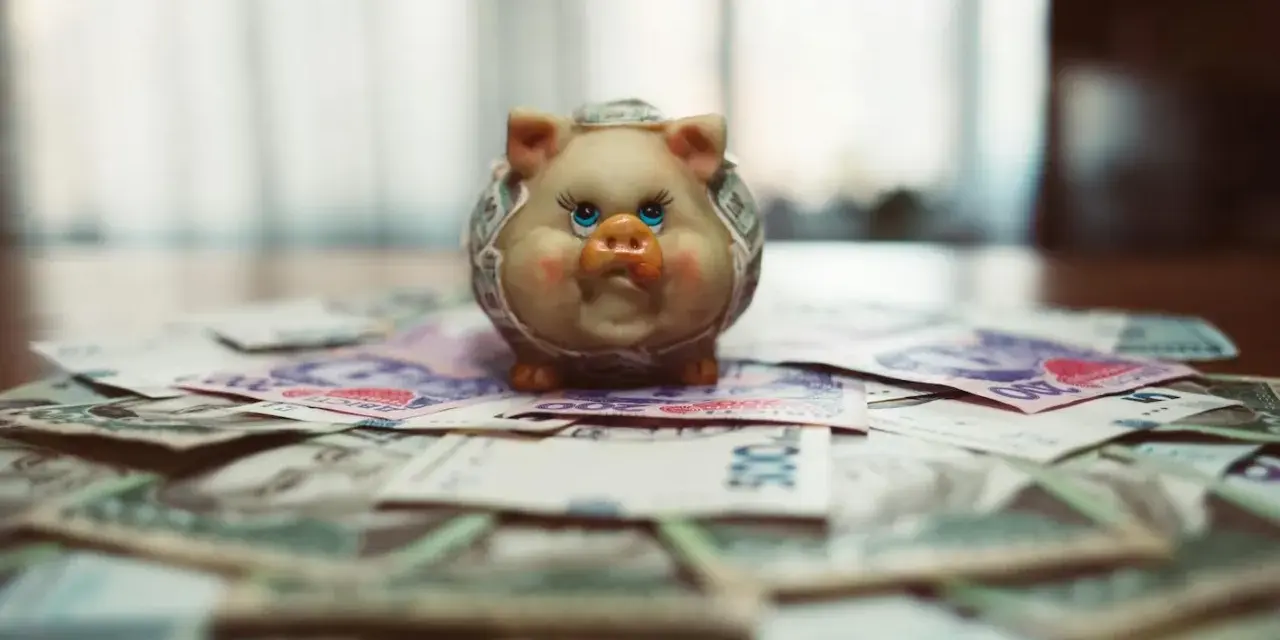 Un cochon tirelire sur des billets de banque, symbolisant le coût de la vie à Singapour pour un étudiant.