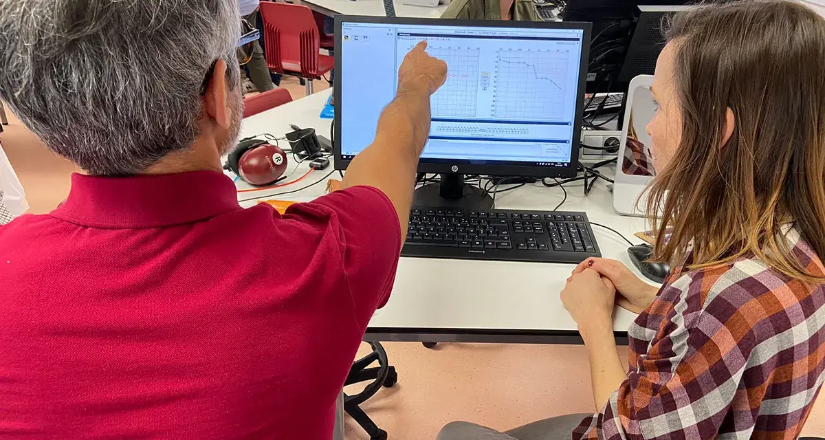 Un homme montre un audiogramme sur un écran, peut-être lors d'une formation pour obtenir son diplôme d'audioprothésiste en Espagne.