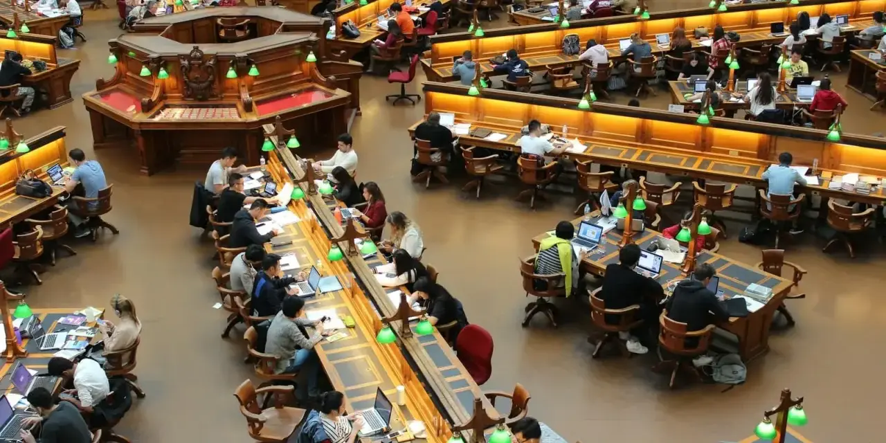 Vue d'ensemble d'une grande bibliothèque où des étudiants travaillent sur leurs ordinateurs portables. Le coût de la vie en Écosse, notamment pour les études, est un sujet de préoccupation.