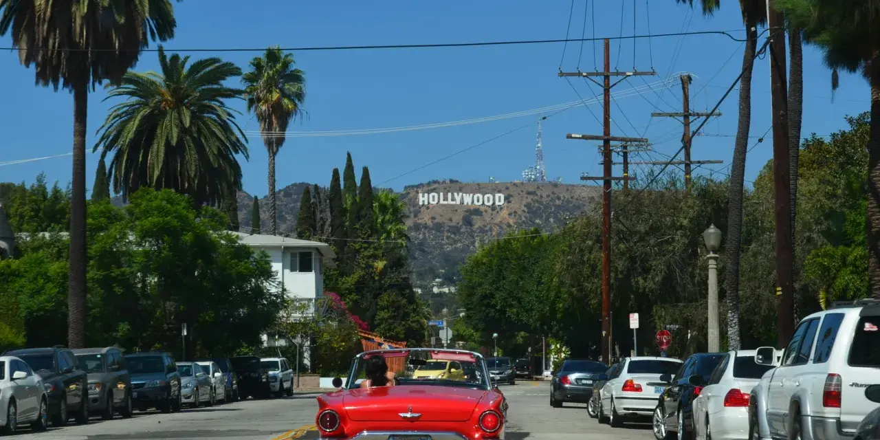 Voiture rouge décapotable, palmiers, panneau Hollywood. Le cout de la vie USA, un rêve pour certains, une réalité coûteuse pour d'autres.
