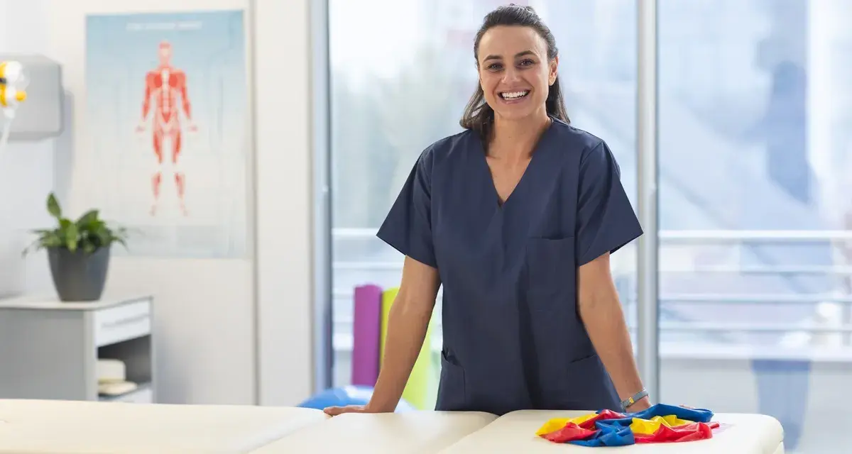 Une kinésithérapeute souriante dans sa salle de soins, prête à accueillir ses patients. L'école kine Saragosse forme des professionnels de santé.