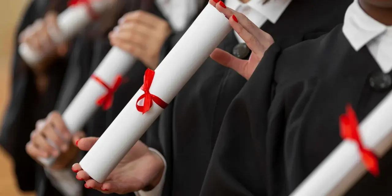Diplômés en toges noires tenant des parchemins, un rêve pour ceux qui veulent faire ses études de kiné en Europe.
