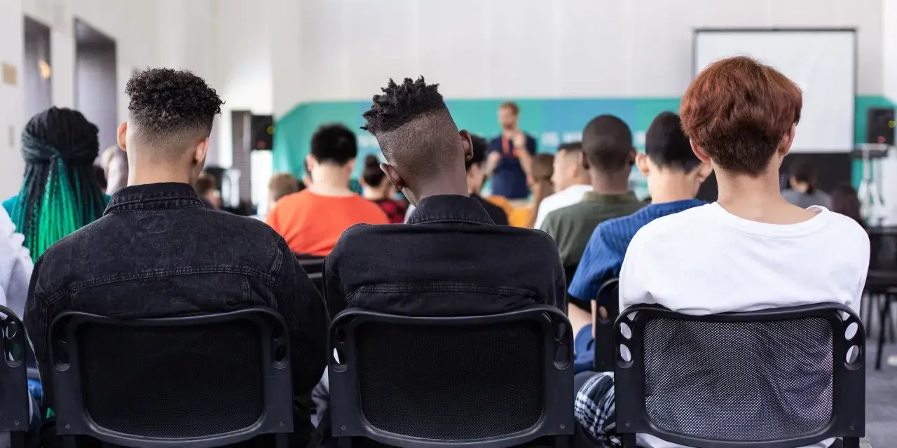Des étudiants écoutent un conférencier, peut-être lors d'un événement sur le prix de l'université de New York.