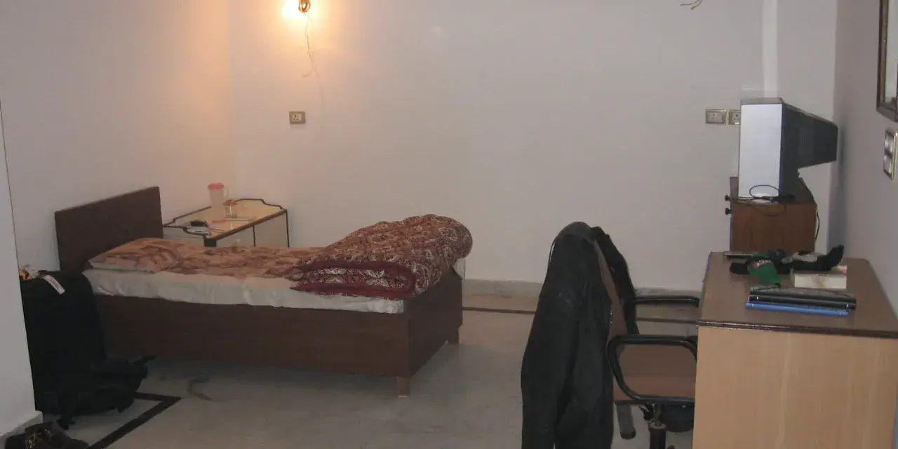 Chambre modeste en Inde, avec un lit, un bureau et une télévision. Un aperçu du cout de la vie en Inde.