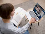 Étudiante en licence neurosciences à distance, elle étudie sur son ordinateur portable et des livres ouverts.