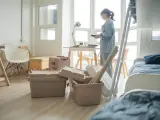 Une jeune femme déballe ses affaires dans une chambre d'étudiant au Canada. Valises et boîtes sont empilées, prête pour une nouvelle vie.