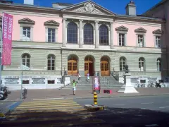 Bâtiment de l'université de Genève, avec une bannière "Université de Genève" et un buste sur un piédestal.
