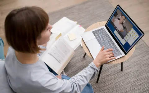 Étudiante en licence neurosciences à distance, elle étudie sur son ordinateur portable et des livres ouverts.