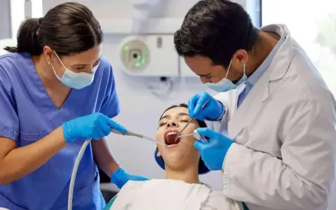 Dentiste et assistante examinant une patiente. Le coût d'une étude orthodontiste peut varier.