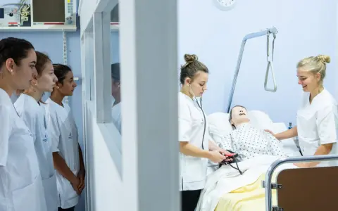 Étudiantes en formation à une école d'infirmière en Belgique. Elles apprennent les gestes de soins sur un mannequin.