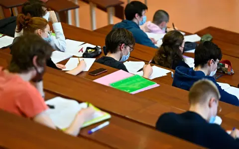 Étudiants masqués en classe, concentrés sur leurs notes. Un aperçu du coût de la vie au Danemark, où l'éducation est une priorité.