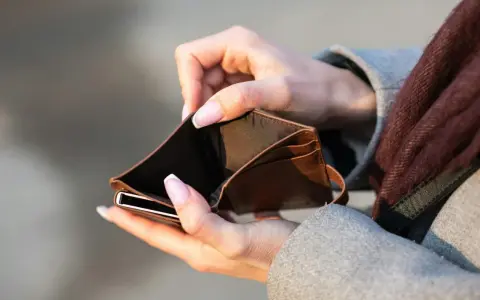 Mains tenant un portefeuille vide. Le coût de l'école de kiné au Portugal est une préoccupation.