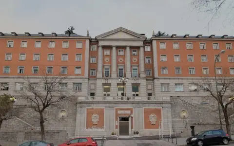 Bâtiment en brique avec des colonnes, des fenêtres et un toit mansardé. Le nom "CEU San Pablo" est visible sur la façade.