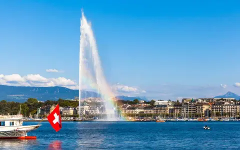 Le Jet d'Eau de Genève, un arc-en-ciel dans la brume, symbolise la beauté de comment vivre en Suisse.