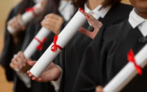 Diplômés en toges noires tenant des parchemins, un rêve pour ceux qui veulent faire ses études de kiné en Europe.
