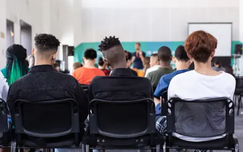 Des étudiants écoutent un conférencier, peut-être lors d'un événement sur le prix de l'université de New York.