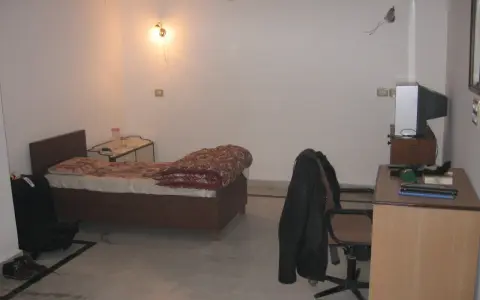 Chambre modeste en Inde, avec un lit, un bureau et une télévision. Un aperçu du cout de la vie en Inde.