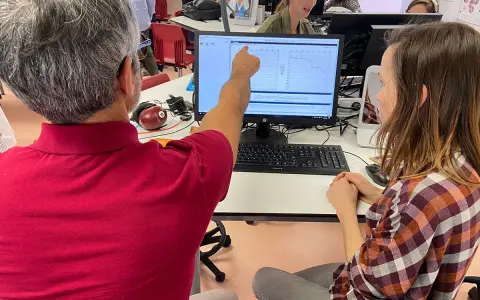 Un homme montre un audiogramme à une femme, lors d'une formation audioprothésiste Espagne à distance.
