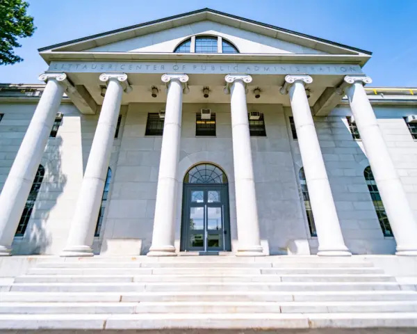 Le Littauer Center of Public Administration, un bâtiment emblématique d'une université américaine connue, se dresse fièrement avec ses colonnes imposantes et son escalier majestueux.