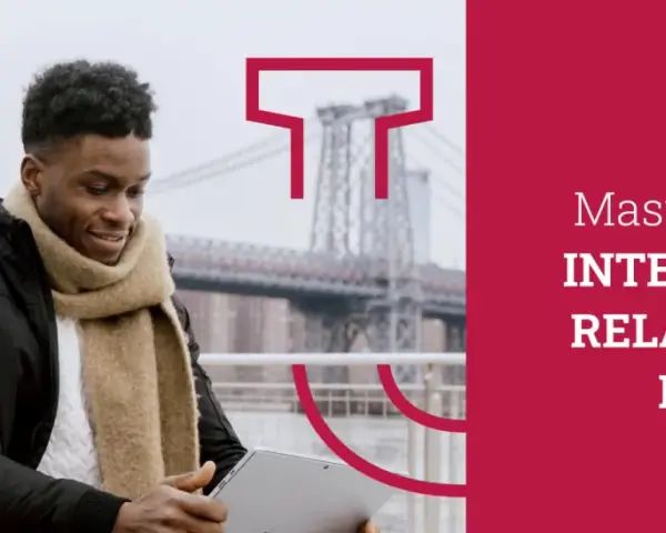 Un jeune homme étudie sur sa tablette, prêt à commencer son master relations internationales à distance.