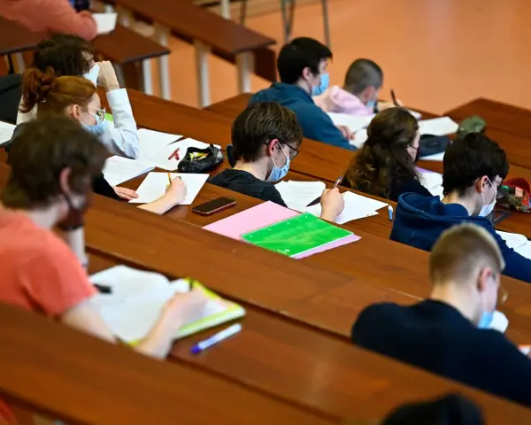 Étudiants masqués en classe, concentrés sur leurs notes. Un aperçu du coût de la vie au Danemark, où l'éducation est une priorité.
