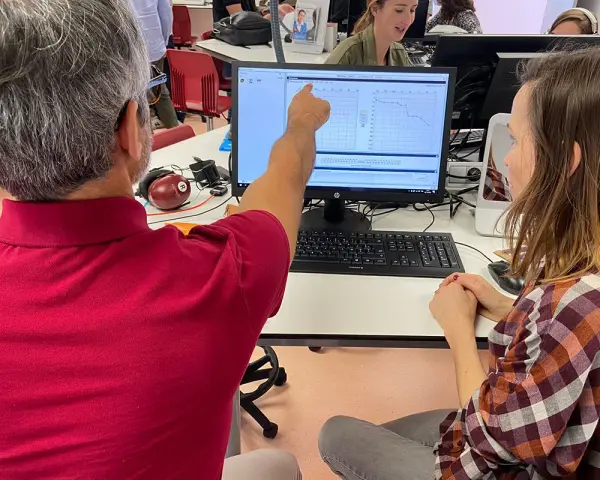 Un homme montre un audiogramme sur un écran, peut-être lors d'une formation pour obtenir son diplôme d'audioprothésiste en Espagne.