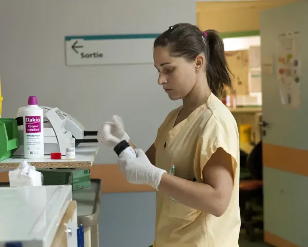Une étudiante en soins infirmiers à l'école d'infirmière Bruxelles prépare un médicament.