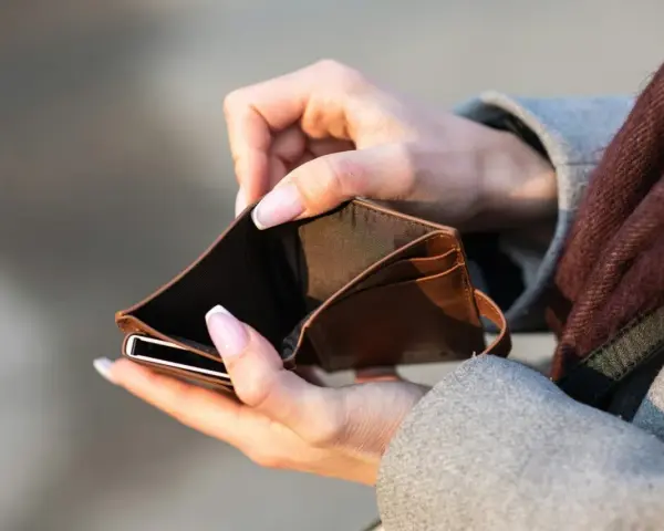 Mains tenant un portefeuille vide. Le coût de l'école de kiné au Portugal est une préoccupation.