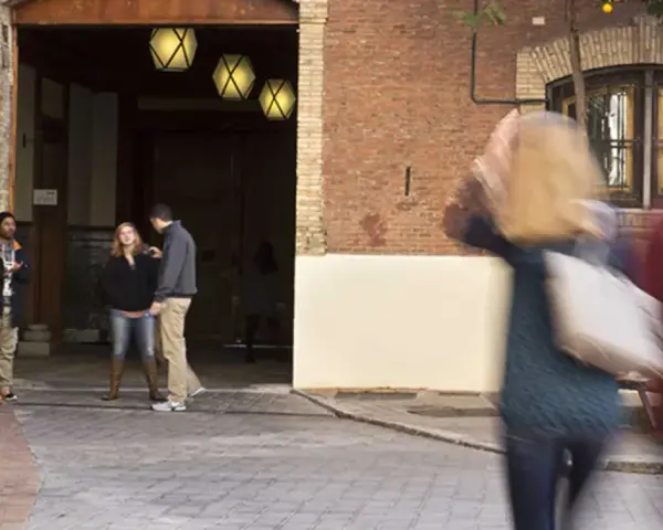 Des étudiants discutent dans une cour d'une vieille bâtisse, un lieu qui pourrait être un master à Madrid.