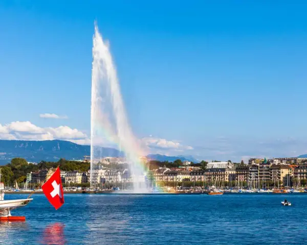 Le Jet d'Eau de Genève, un arc-en-ciel dans la brume, symbolise la beauté de comment vivre en Suisse.