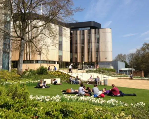 Étudiants profitant du soleil sur la pelouse devant le bâtiment de la **université de Southampton**.
