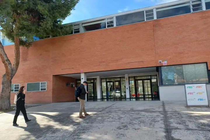 Étudiants se promenant devant le bâtiment de la faculté de sciences économiques de l'université d'Alicante.
